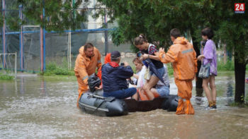 Спасатели помогают керчанам пересекать затопленные улицы